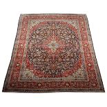 A KESHAN CARPET, PERSIA, MODERN the deep indigo blue field with a red and ivory floral medallion