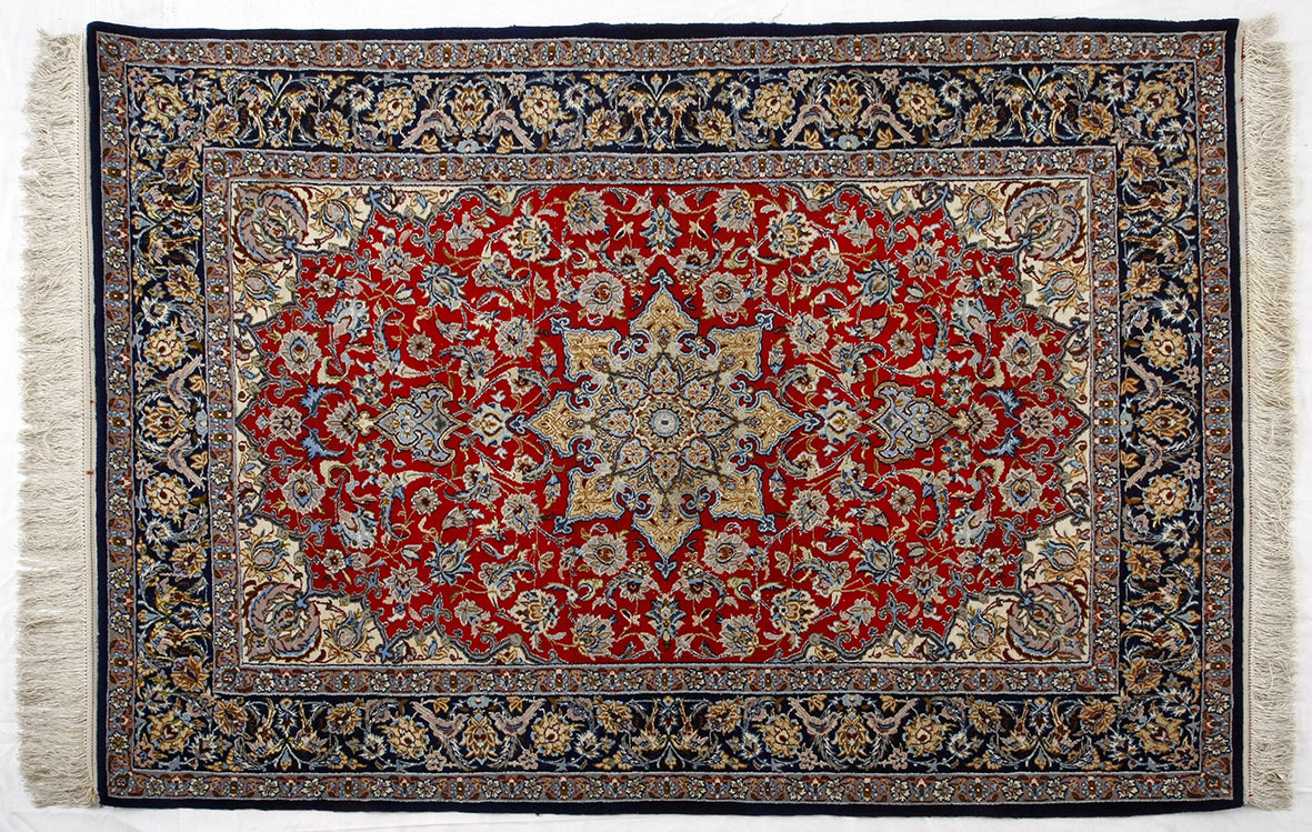 AN ISPAHAN RUG, PERSIA, MODERN the red field coils with a blue and gold floral star medallion, ivory