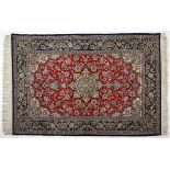 AN ISPAHAN RUG, PERSIA, MODERN the red field coils with a blue and gold floral star medallion, ivory