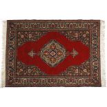 A TURKISH RUG, MODERN the madder field with two diamond medallions depicted in slate blue within a