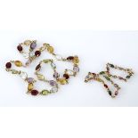 A GEM-SET NECKLACE composed of a series of spectacle-set oval mixed-cut semi-precious gems,