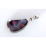 AN OPAL PENDANT the free form opal on matrix, within a conforming silver surround, impressed 925,