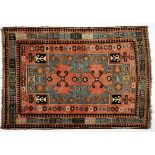 AN AFGHAN RUG, MODERN the rose field with a bold green medallion containing two rose guls, all
