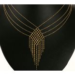 A GOLD NECKLACE comprised of four strands of ball-chain terminating in a checkerboard diamond,
