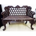 A CAST-IRON GARDEN BENCH, 19TH CENTURY the pierced and moulded back surmounted by scrolling foliage,