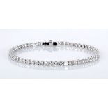 A DIAMOND TENNIS BRACELET claw-set with fifty-eight brilliant-cut diamonds weighing approximately