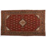 A CAUCASIAN RUG, AZERBAJAN, MODERN the red field with a small ivory stepped medallion and