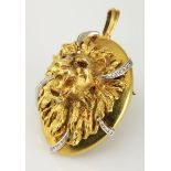 A GOLD PENDANT/BROOCH of oval form depicting a lion's head, embellished with channel-set brilliant-