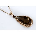 A SMOKY QUARTZ PENDANT centred with a pear-shaped smoky quartz weighing approximately 15.77cts,