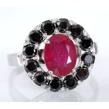 A RUBY RING centred with an oval ruby weighing approximately 2.23cts, within a surround of