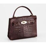 A VINTAGE CROCODILE SKIN HANDBAG NOT SUITABLE FOR EXPORT glossy burgundy leather with gold metal
