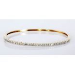 A DIAMOND BANGLE of oval form, embellished with brilliant-cut diamonds weighing approximately 0.