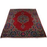 A KIRMAN CARPET, PERSIA, MODERN the plain red field with a bold floral medallion and pendant