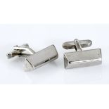 A PAIR OF STAINLESS STEEL CUFFLINKS each of stylised trapezoid form, with hinged baton fittings (2)