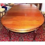 A VICTORIAN MAHOGANY EXTENDING DINING TABLE each D-end above a plain frieze, on two turned