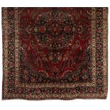 A MESHED CARPET, EAST PERSIA, MODERN the burgundy-red field with a dark blue round floral