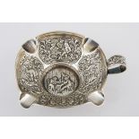A SILVER ASHTRAY, POSSIBLY DUTCH the centre and four panels chased with figures in various pursuits,