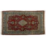 A QUM RUG, PERSIA, MODERN the red field with a blue and gold floral diamond medallion and