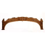 A VICTORIAN TEAK ARCH surmounted and centred by a shell motif flanked by griffons, on square-section