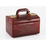 A CROCODILE VANITY CASE NOT SUITABLE FOR EXPORT of burgundy colour and gold hardware, with