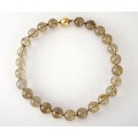 A RUTILATED QUARTZ NECKLACE composed of rutilated quartz beads, approximately 16mm in diameter, with