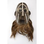 A ZIBE MASK, TANZANIA decorated with white patterns and adorned with a beard 30cm high