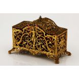 A FRENCH GILT METAL AND CRANBERRY GLASS CADDY, LATE 19TH CENTURY of rectangular outline, cast and