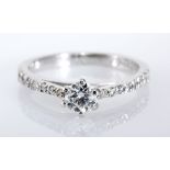 A DIAMOND RING centred with a claw-set brilliant-cut diamond weighing 0.35cts, the shoulders