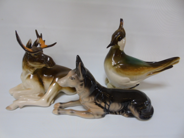 A Lemonosov figure of a moose another of a bird plus 1 other Russian figure of a dog