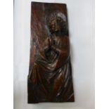 A Carved wooden plaque depicting a praying figure
