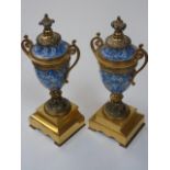 A pair of handpainted clock garnitures of trophy form
