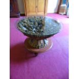 Circular driftwood coffee table glass top and raised on a wheeled wooden base