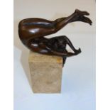 Cast bronze of a nude female with legs raised, her hair cascading on a marble plinth   Approx 11"