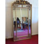 Large gilt framed mirror with floral top. Approx 72" high