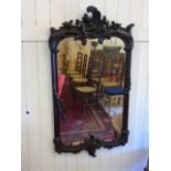 A heavily carved wooden framed wall mirror - approx 43 by 22"