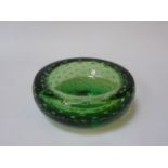 Green glass circular ashtray, possibly Whitefriars with bubble decoration