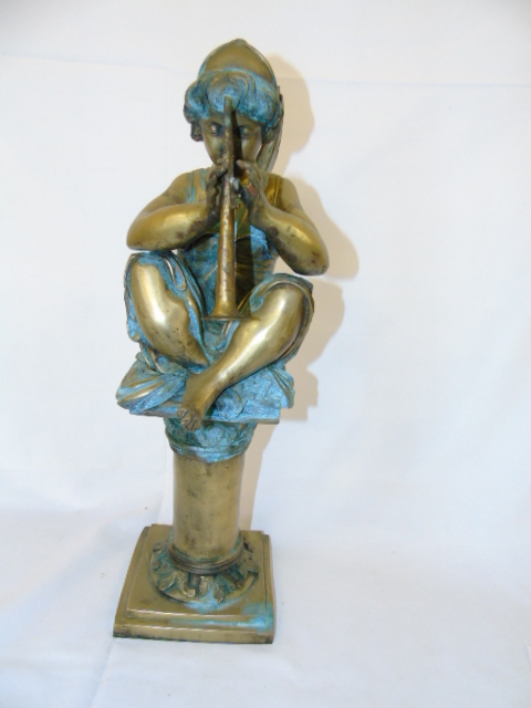A heavy bronze figure of an angel seated on a plinth and playing a horn. approx height 23.5"