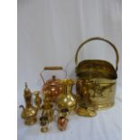 A collection of copper and brass items to include a tea pot, coal scuttle and jugs etc