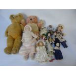 Vintage musical clockwork teddy and a growler teddy and 11 porcelain dolls in costumes