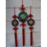 2 Carved jade wall hanging amulets with wood effect surrounds and red tassels along with a larger