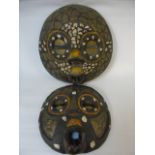 Graduated pair of carved tribal masks with brass bead and shell decoration