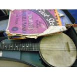 Cased vintage ukulele and sheet music