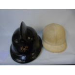 Vintage motor cycle helmet made by Aviarit and a vintage fireman's helmet made by Levior Belgium