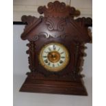 Carved walnut antique clock with gilded and enamel dial approx. 17" tall