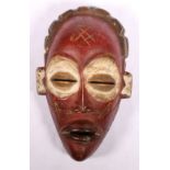 African mask, red painted with scarified