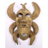 Benin style brass mask head with bird su