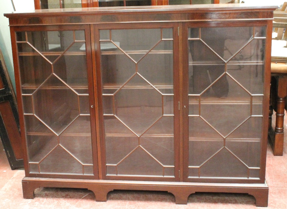 Mahogany bookcase by Wylie & Lochhead, with three astragal glazed doors enclosing adjustable