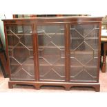 Mahogany bookcase by Wylie & Lochhead, with three astragal glazed doors enclosing adjustable