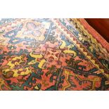 Large Turkish carpet with pink ground, the field decorated with stylised flower heads and lozenges