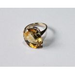 Dress ring with citrine set at an angle, in gold.